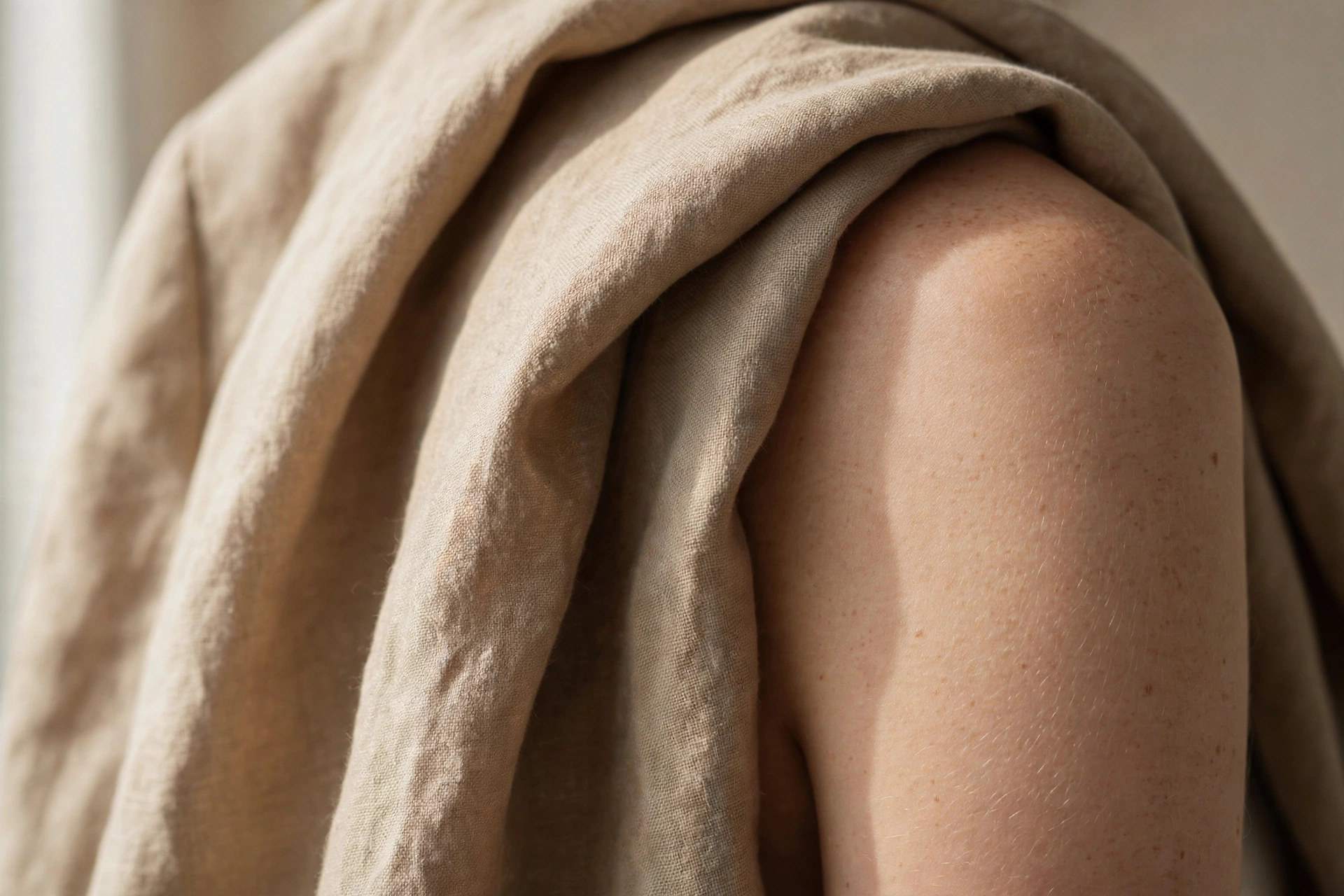 Close-up of soft draped blazer fabric on a woman's shoulder and arm